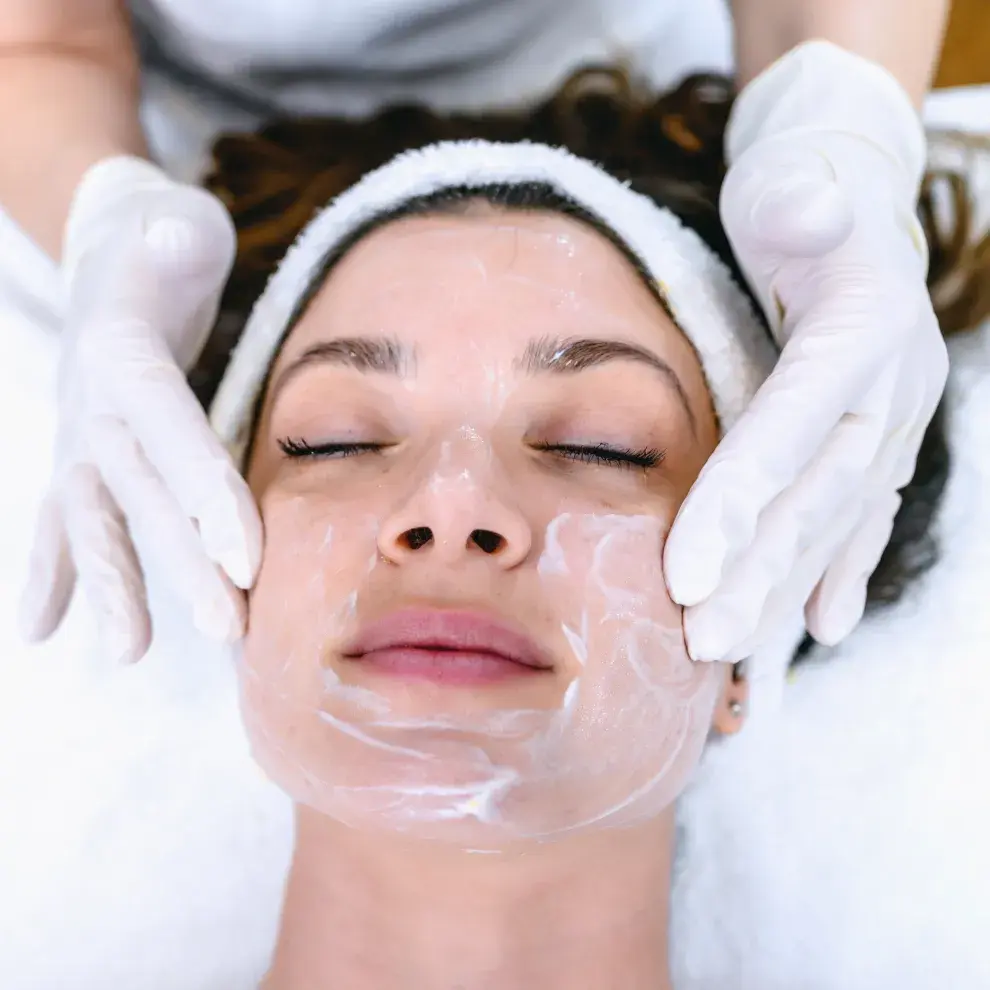 Una mujer haciendose una mascarilla facial