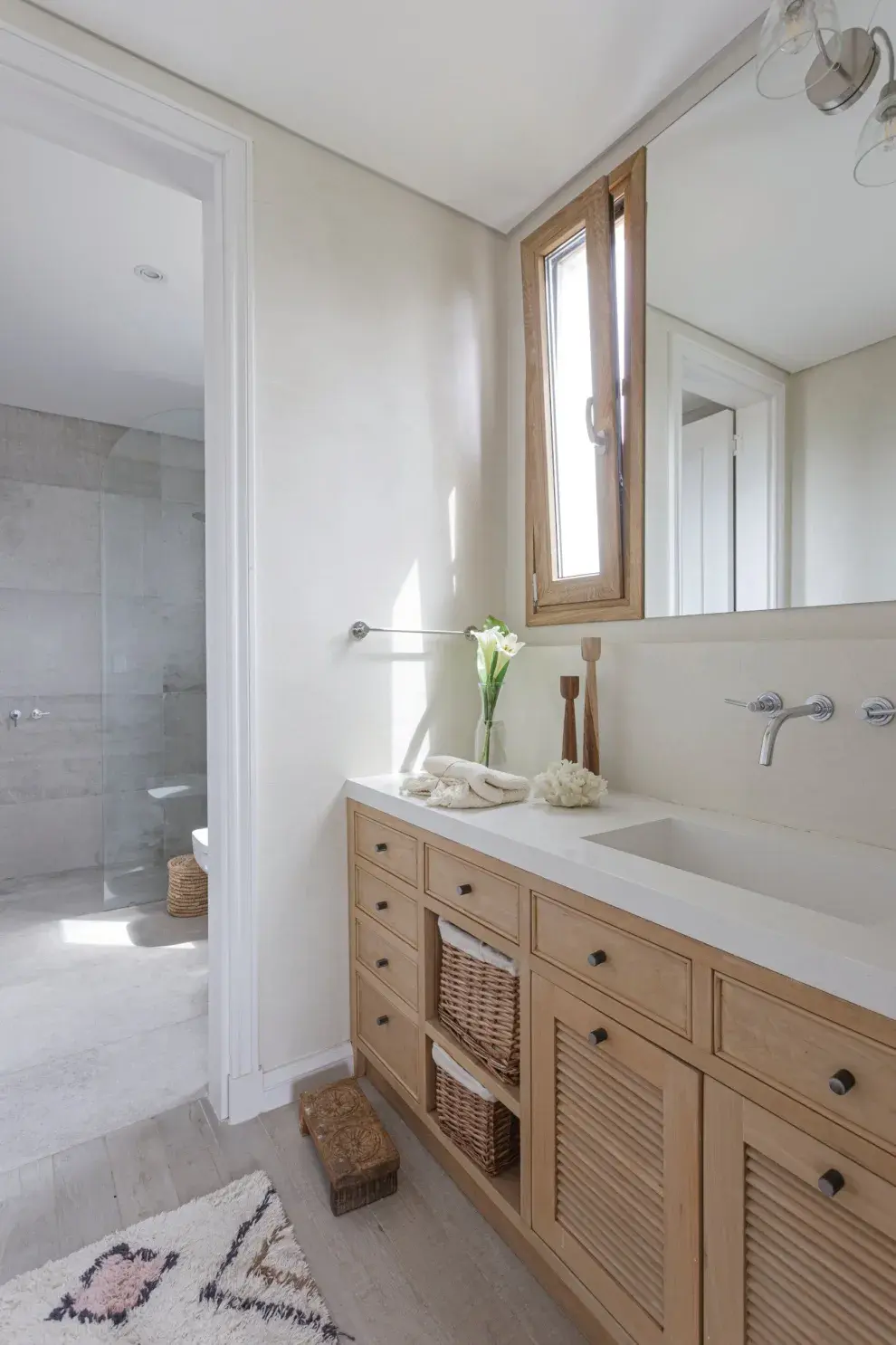 En el baño en suite, mueble diseñado por Ana con mesada de Purastone ‘Blanco Cana’. Alfombra (Seara).