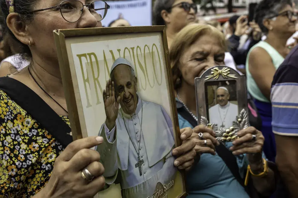 Fieles católicos llevan imágenes del Papa Francisco en una misa al aire libre para orar por él el 24 de febrero de 2025 en Buenos Aires, Argentina