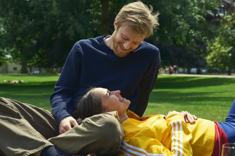 Una pareja sentada en un parque, mirándose con amor.