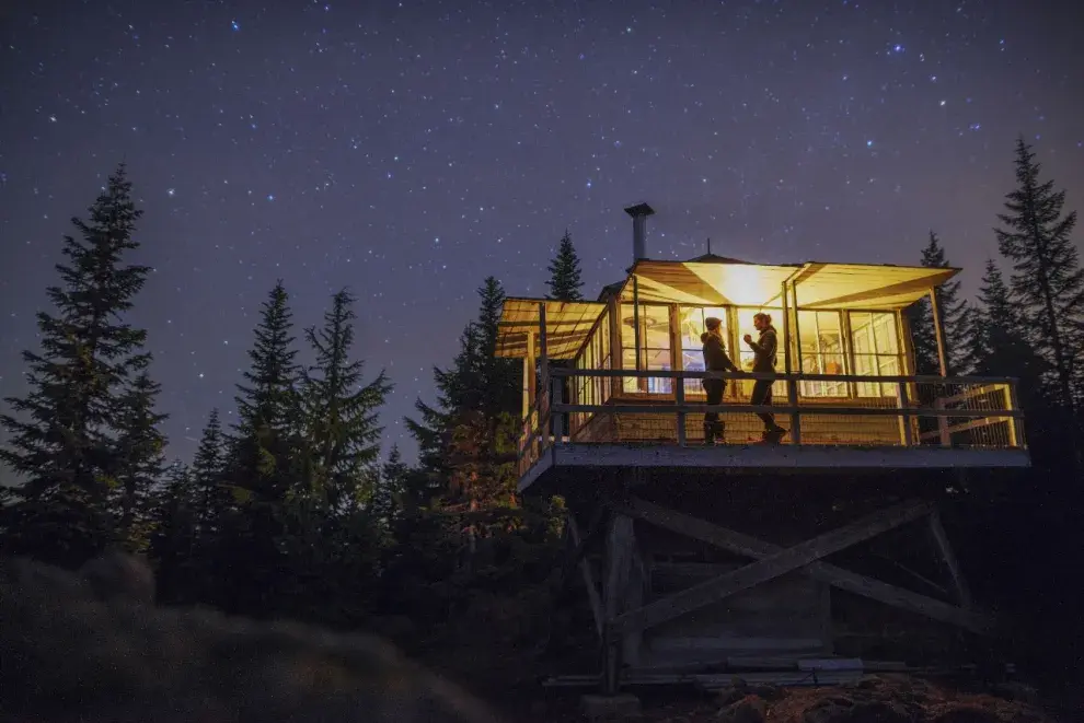 Una pareja en una cabaña bajo un cielo estrellado.