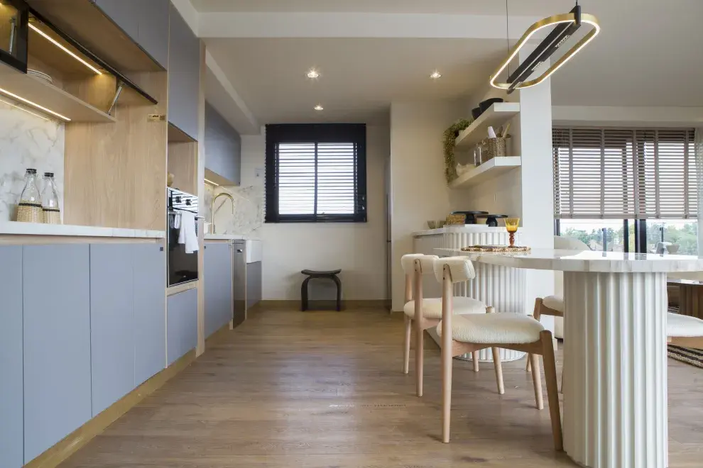 Orlando Deco resolvió muy bien la integración de los ambientes con una mesa-mesada en mármol acanalado.
