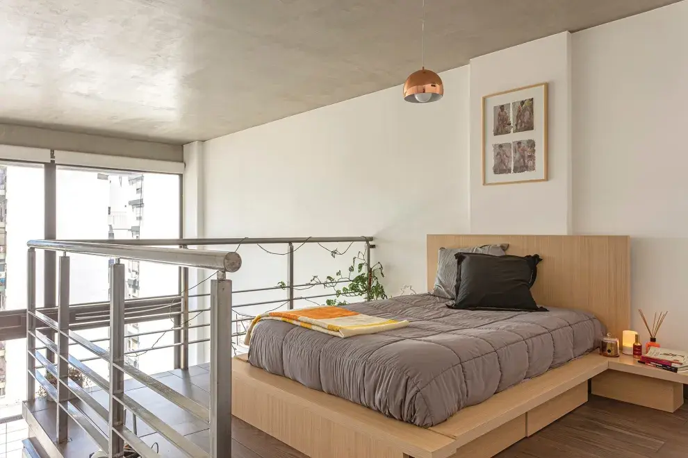 La cama baja estilo tatami es un diseño que el dueño de casa trajo de sus años en Oriente y está en armonía con el estilo minimalista del dormitorio. Sus cajones, mesas de luz y respaldo se encastran para conformar una sola pieza.