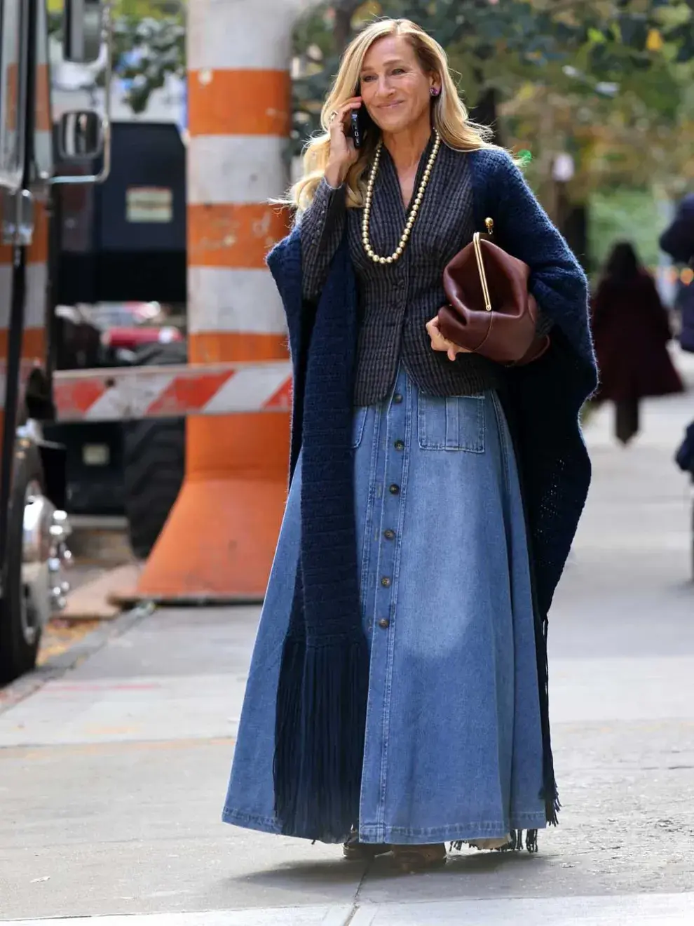 Sarah Jessica Parker con una falda vaquera larga con una chaqueta entallada y un chal largo de punto.