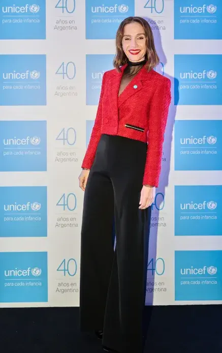 Natalia Oreiro con una chaqueta roja, remera con transparencias y pantalón de tiro alto negro
