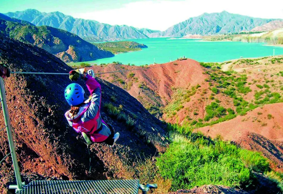 Una chica haciendo canopy sobre el río