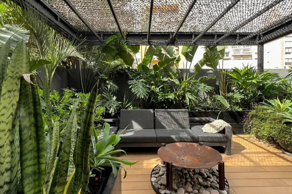 El estudio DIPA Arquitectos hizo una base con piedras para apoyar el fogonero sobre el deck de WPC, un material que combina madera con polímeros reciclados.