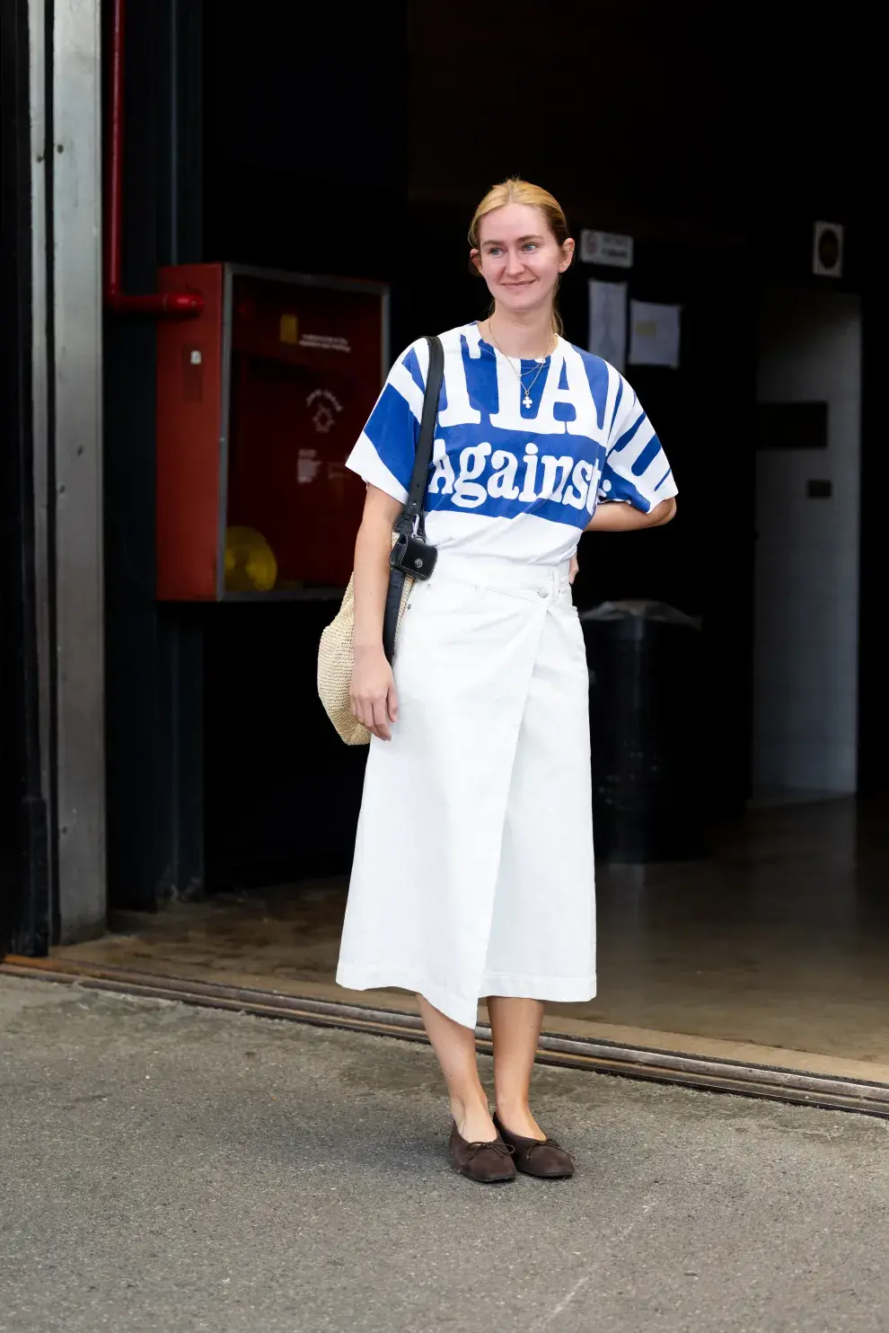 Look de streetstyle en Milan con falda midi y remera estampada.