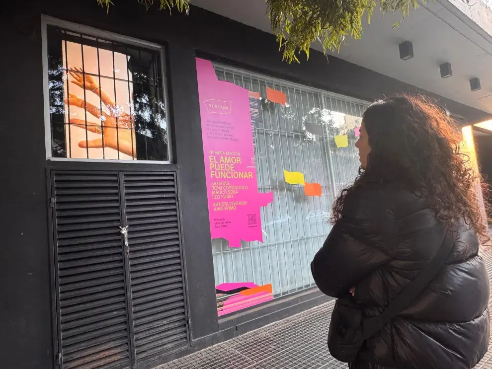 Romina Costigliolo, artista e impulsora de esta galería, mira su obra "Caricias" durante el montaje.