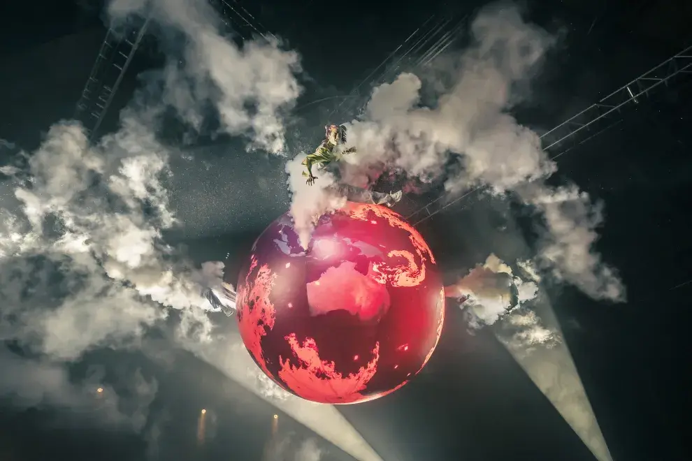 Una persona caminando sobre un globo terráqueo.