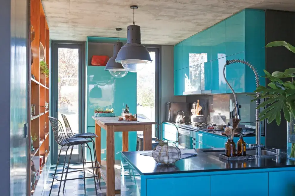 Muebles de cocina laqueados en color turquesa (De Otro Tiempo). Mesada y alzada de Silestone (Casa Bonacina). Bacha (Johnson Acero). Grifería (Franke). Piso de calcáreos (Moltrasio). Vajilla y macetas de cerámica hechas a mano (Ozono Cerámica).