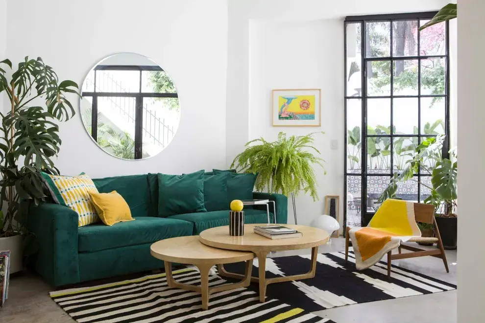Sillón cubo tapizado en pana verde inglés, almohadones estampados a mano (Mercedes Segura), mesas bajas ‘Nido’ (Harturo).