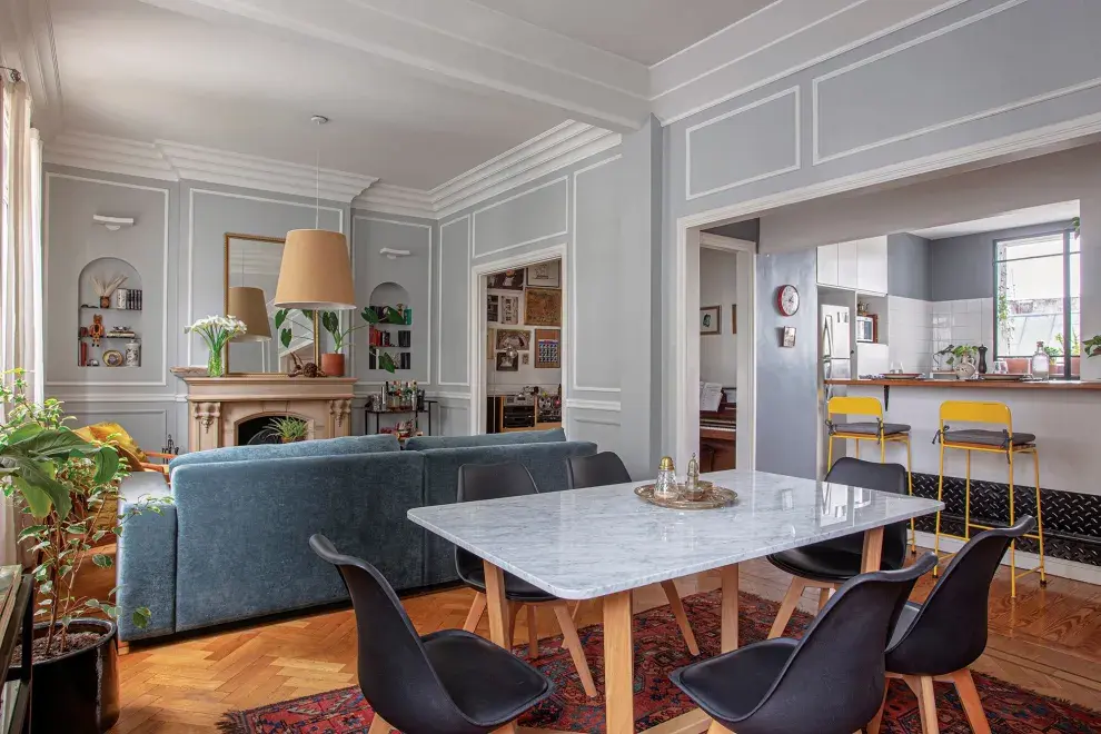En el sector del comedor, mesa de hecha a medida en petiribí y mármol de Carrara y sillas ‘Cross Wood’ con patas de madera.