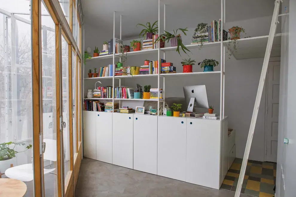 Hecha con una liviana estructura de hierro y melamina, la biblioteca delimita el dormitorio sin quitarle luz, que es siempre uniforme gracias a la orientación sur del departamento.