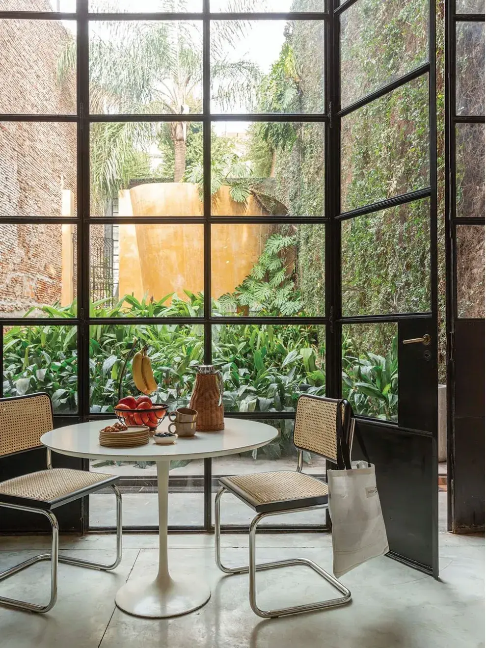Dos potencias: las Cesca, de Marcel Breuer junto a la mesa Tulip en un rincón cómodo, elegante y ligero, fácil de imaginar para pocos metros.