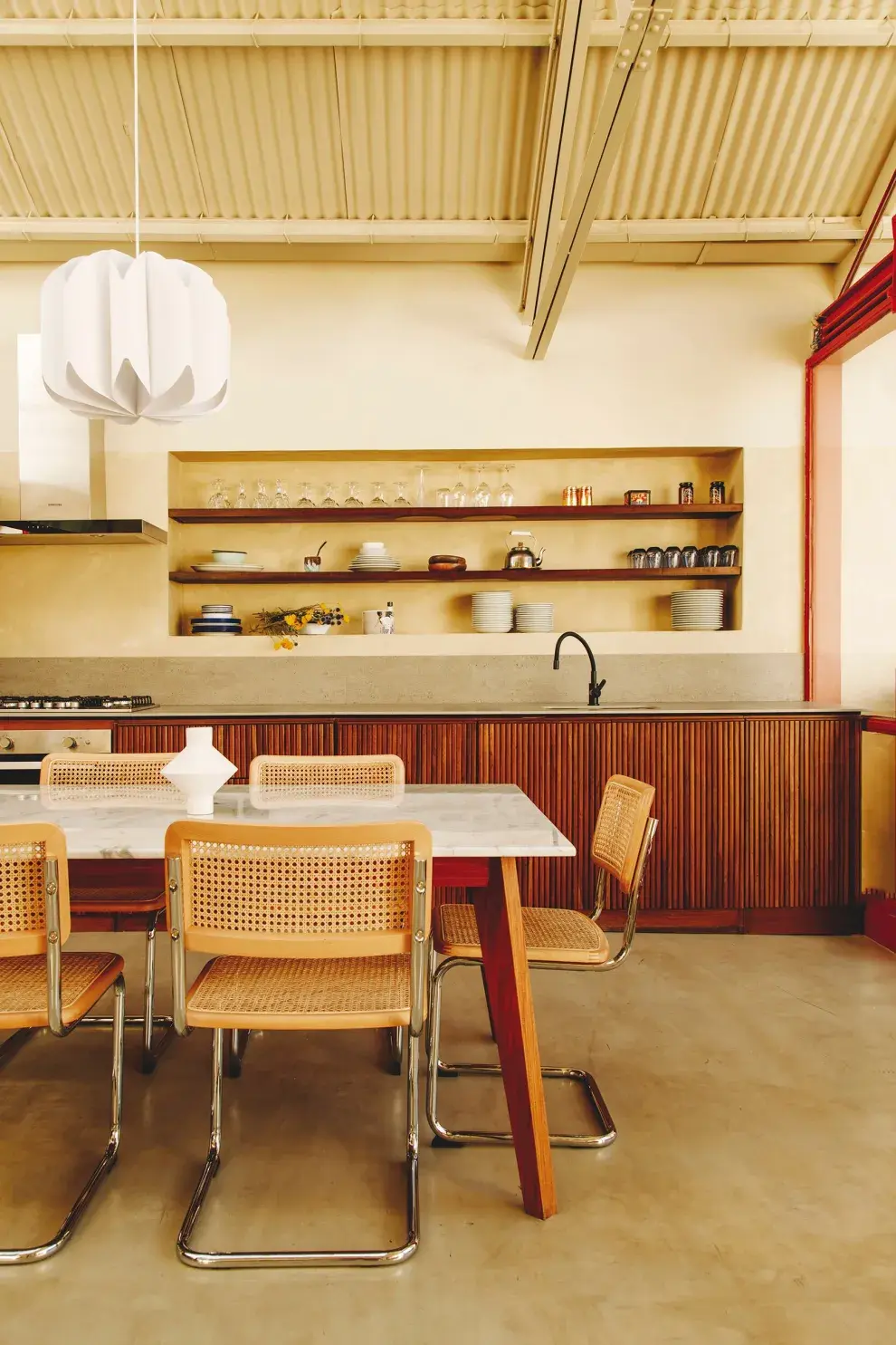 Las sillas Cesca (Landmark) dan el toque perfecto en este comedor diario con mueble bajomesada con frente varillado (Eme Carranza), estructura que se repite para contener la heladera (Samsung). Mesa con tapa de mármol (Canteras del Mundo).