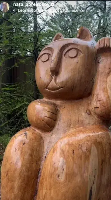 Entre el follaje, aparece otro tesoro: una escultura de madera del clásico Maneki-neko, el gato de la suerte japonés. 