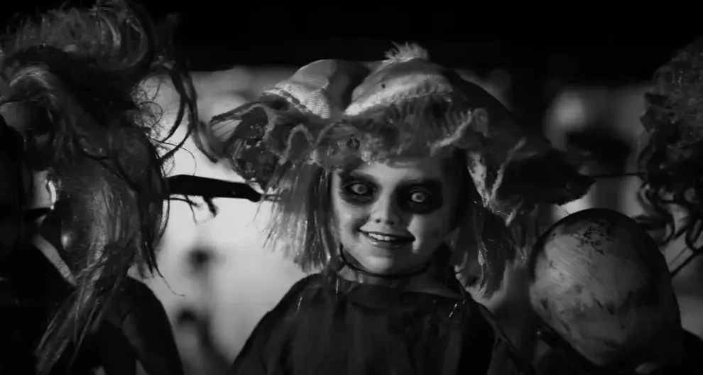La estética visual alterna luces violetas y azules, con una fotografía que evoca las películas de terror retro.