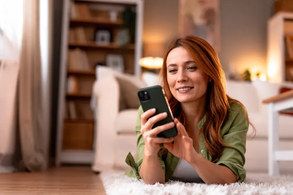 Foto de mujer con celular en mano