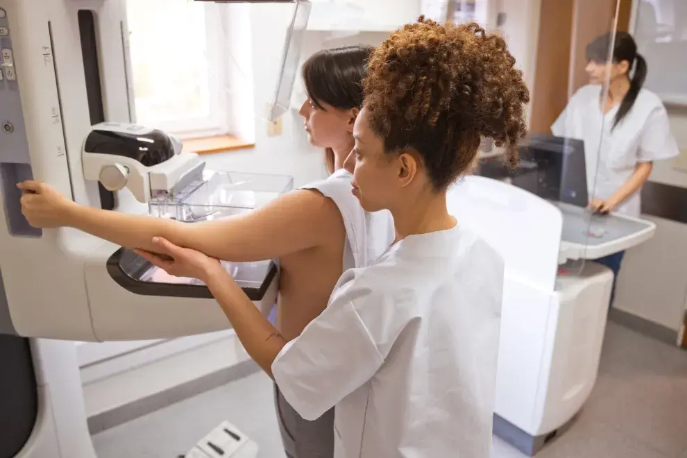 Doctora y mujer joven durante la prueba de mamografía en la sala de examen.