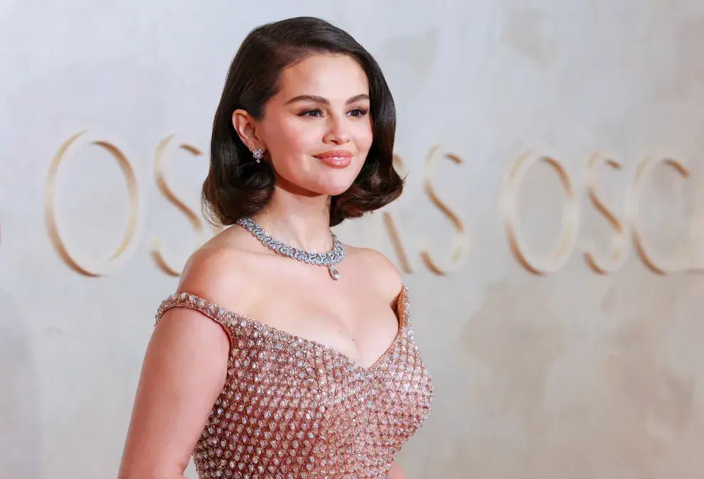 Selena Gómez combinó su vestido dorado con joyas en plateado. 