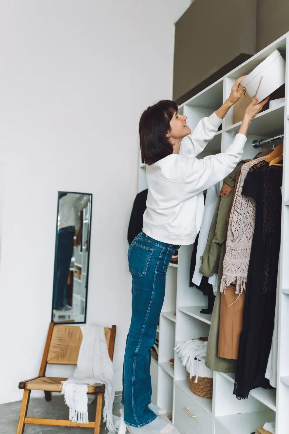 Foto de mujer ordenando ropa.