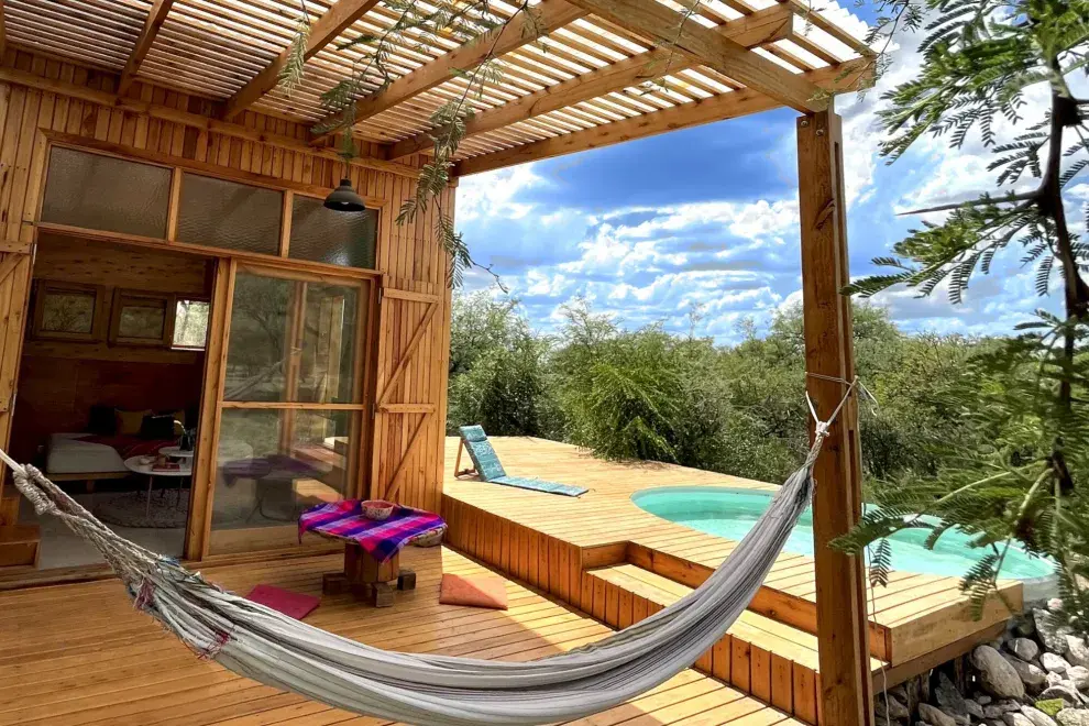 Las expansiones exteriores de la casita (galería, deck con pileta, pérgola y balcón mirador) ocupan la misma superficie que el interior, sumando áreas para habitar el medio circundante. 