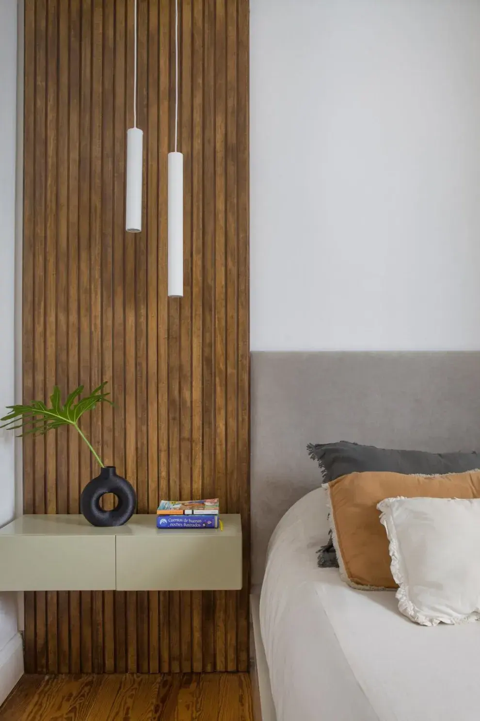 Lámparas colgantes cilíndricas de Paraná 201. Mesas de luz flotantes diseñadas por Aserrín Hace Ran. Revestimiento de pared en varillas de madera.