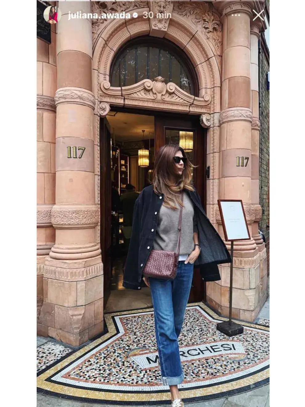 Juliana Awada con jean mom, sweater gris y chaqueta azul