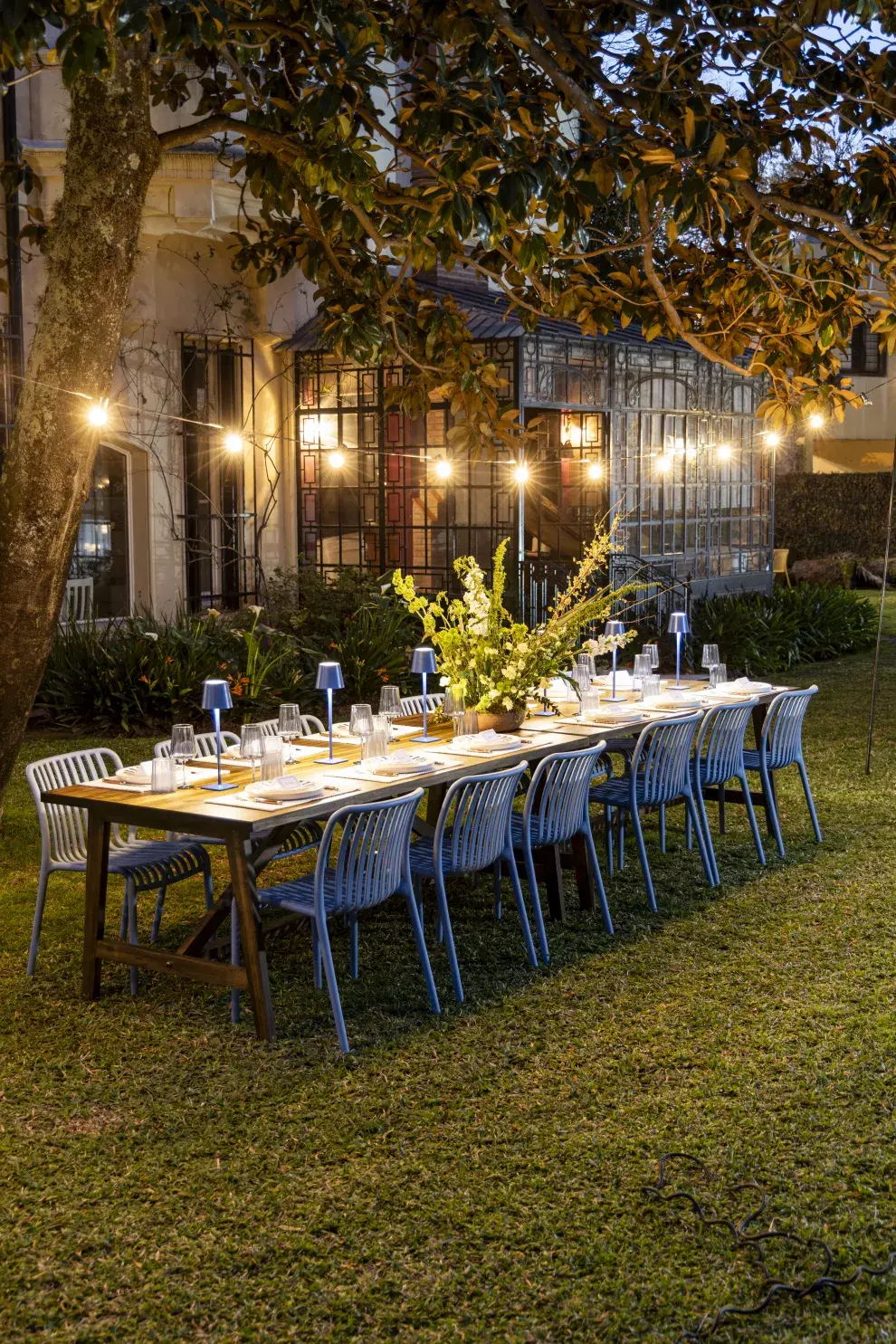 Una mesa con luces cálidas, colores neutros y detalles con flores, es perfecta para Noche Buena y Navidad.