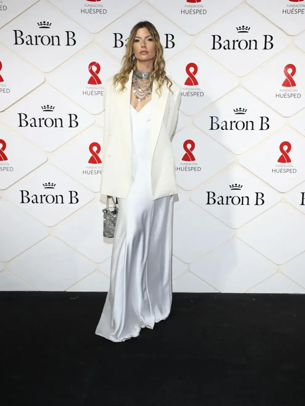 Chloé Bello en look total White sobre la red carpet