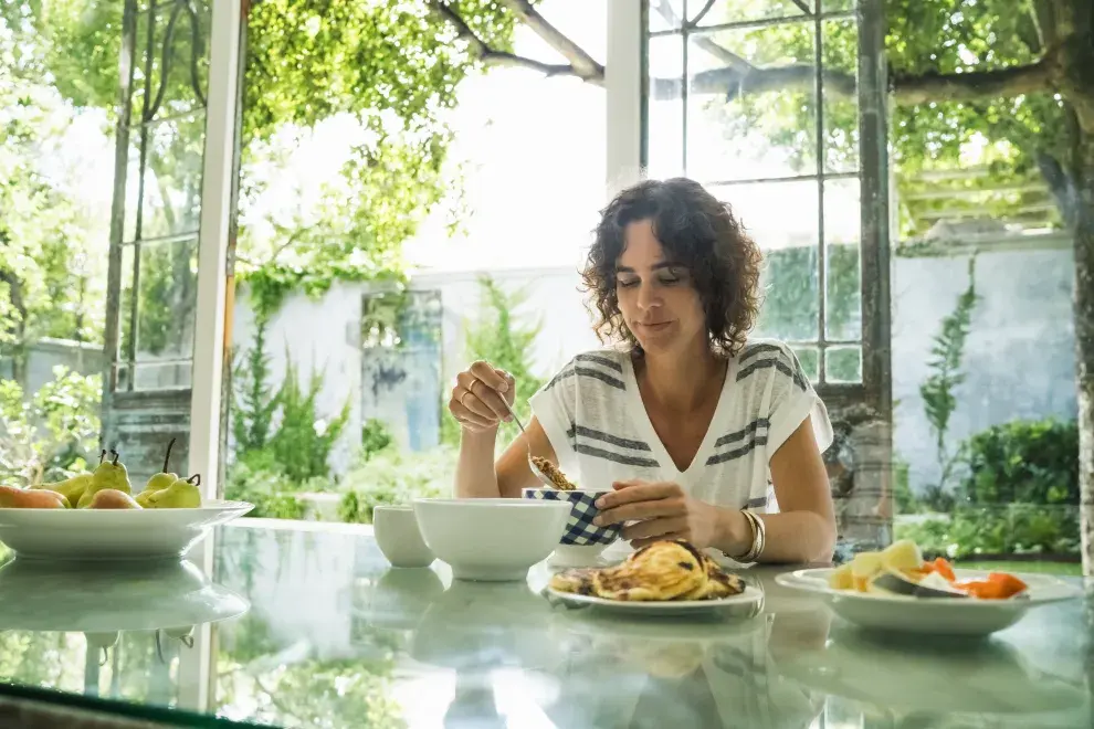 Foto de mujer almorzando.