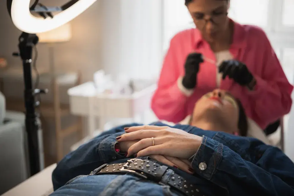 Foto de esteticista trabajando pestañas.