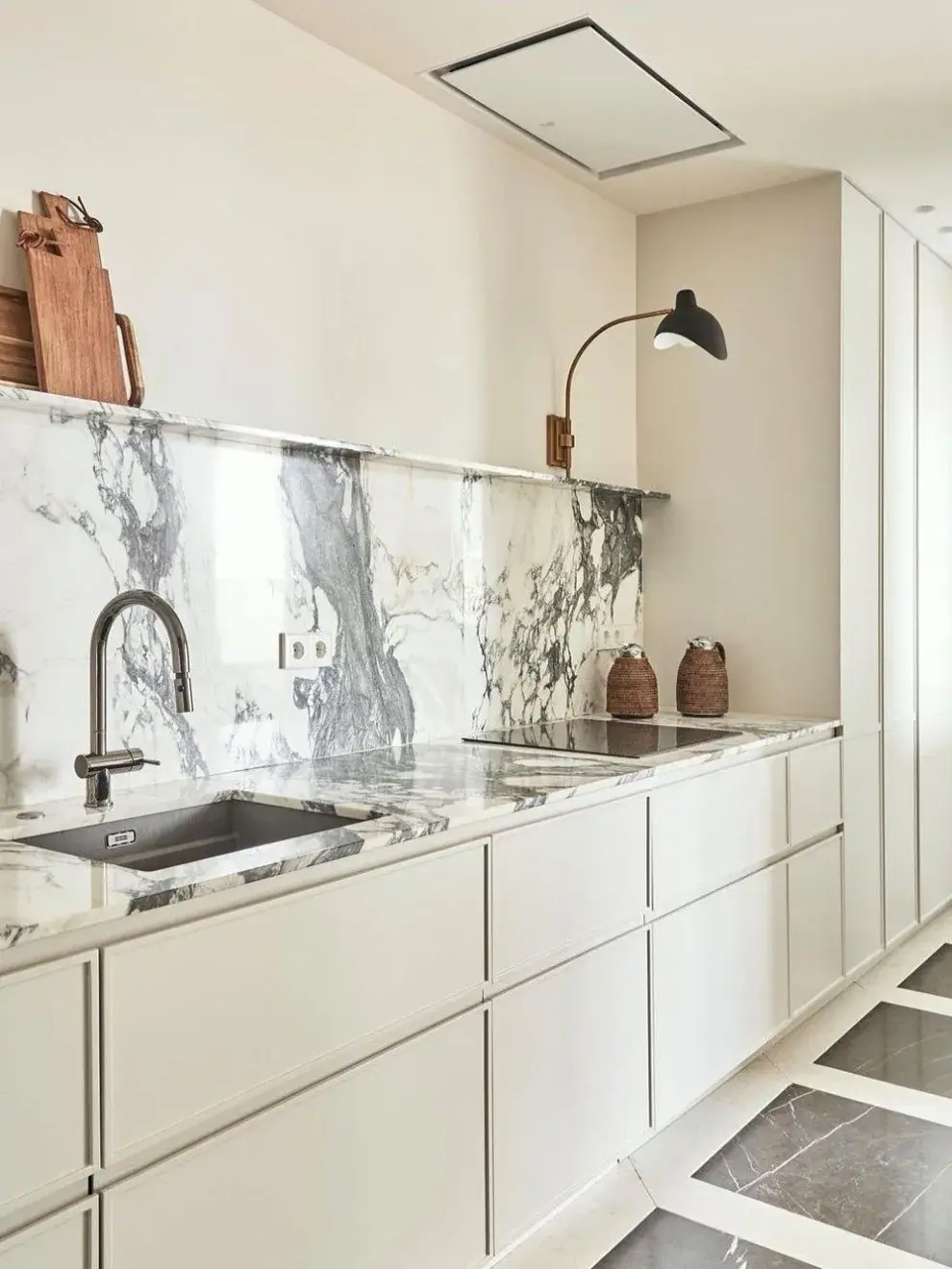 Las mesadas, los muebles bajos y los electrodomésticos integrados son los únicos elementos visibles, lo que contribuye a una sensación de orden y armonía.