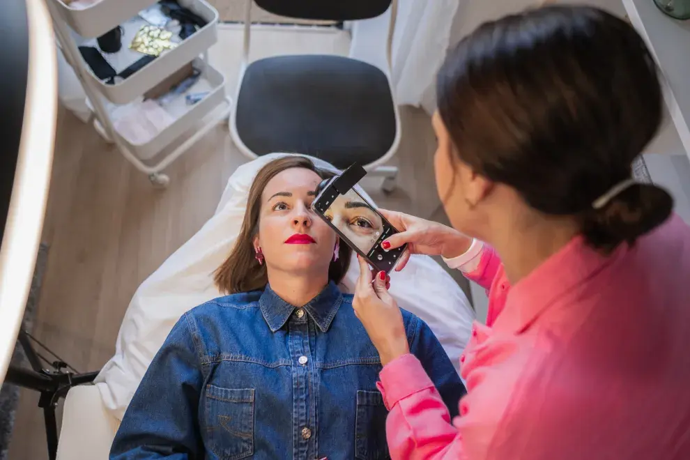 Foto de esteticista trabajando pestañas.