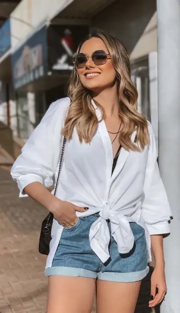 Foto de mujer con camisa anudada y short de jean.