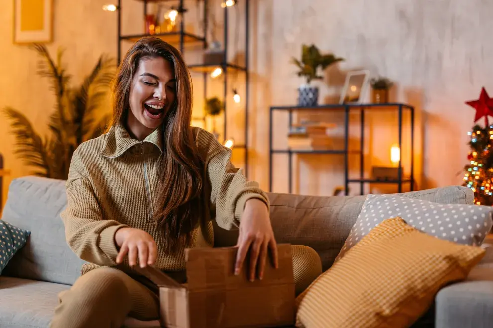 Foto de mujer abriendo regalo.