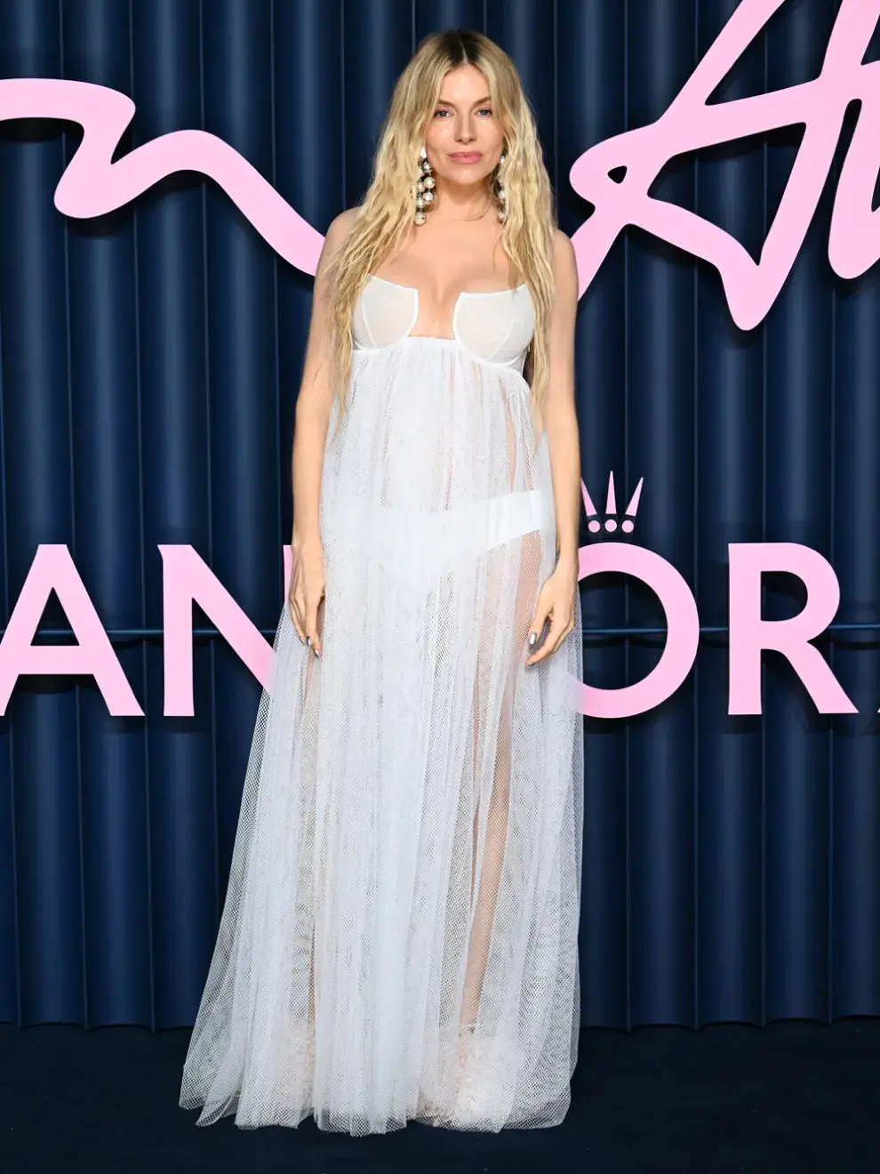 La actriz británico-estadounidense Sienna Miller, de 43 años, sorprendió al mundo en la alfombra roja de los Fashion Awards 2025, celebrados en el Royal Albert Hall de Londres, al revelar su embarazo con un look impactante.