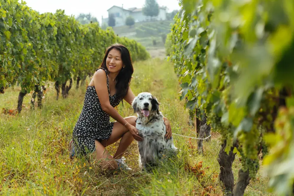 Foto de mujer con su perro en bodega.