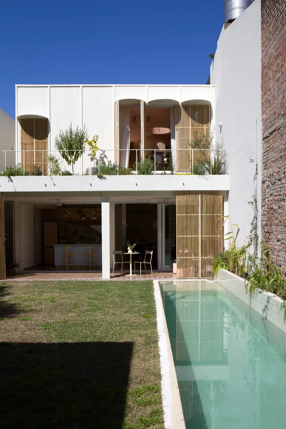 Para no robarle metros al verde y que el agua siga invitando, la pileta se diseñó larga y angosta