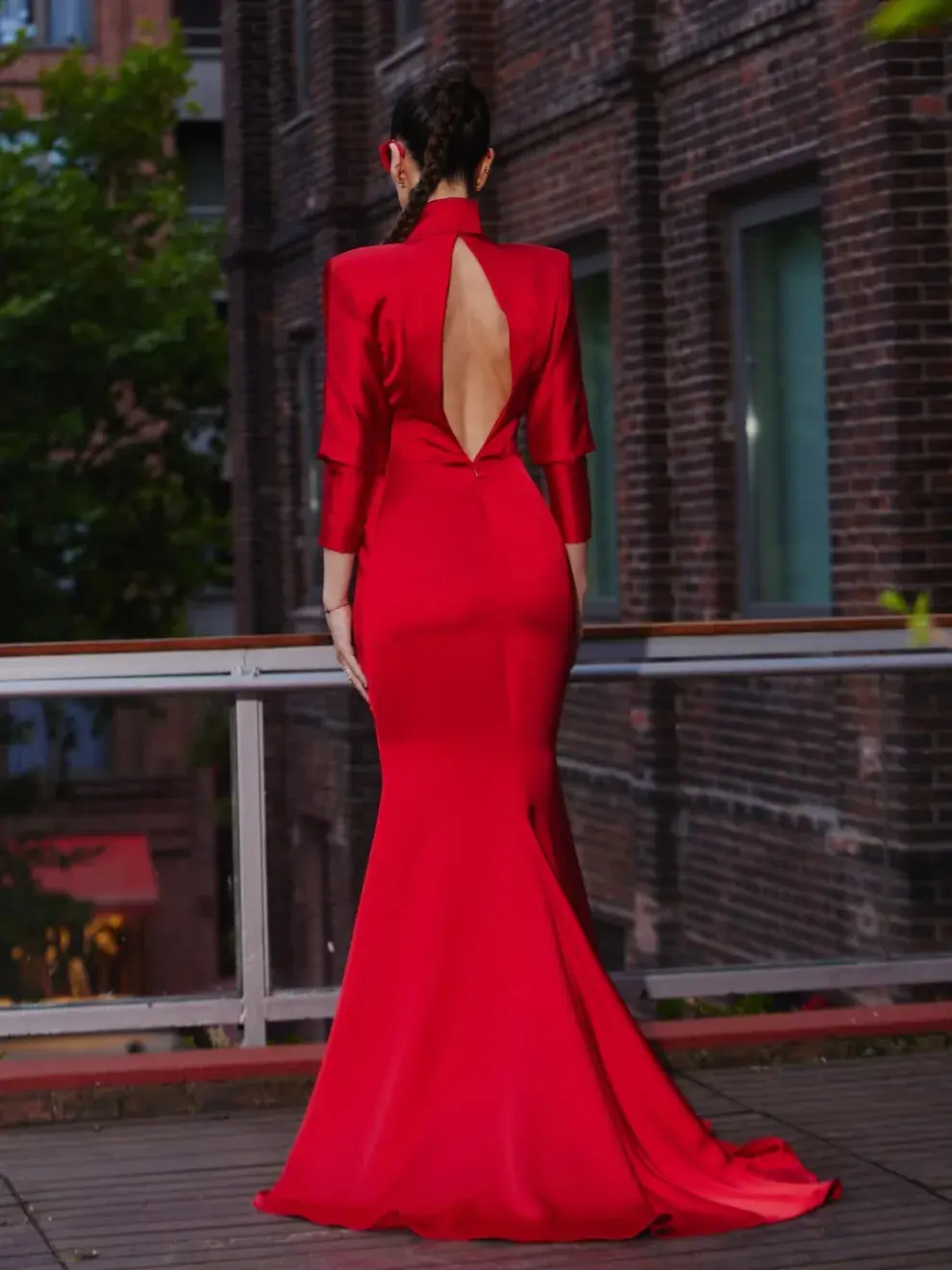 La silueta apuesta por hombros marcados —un guiño al dramatismo característico de los ochenta— que le dan presencia; las mangas dolman, en cambio, suavizan el conjunto y aportan movimiento.