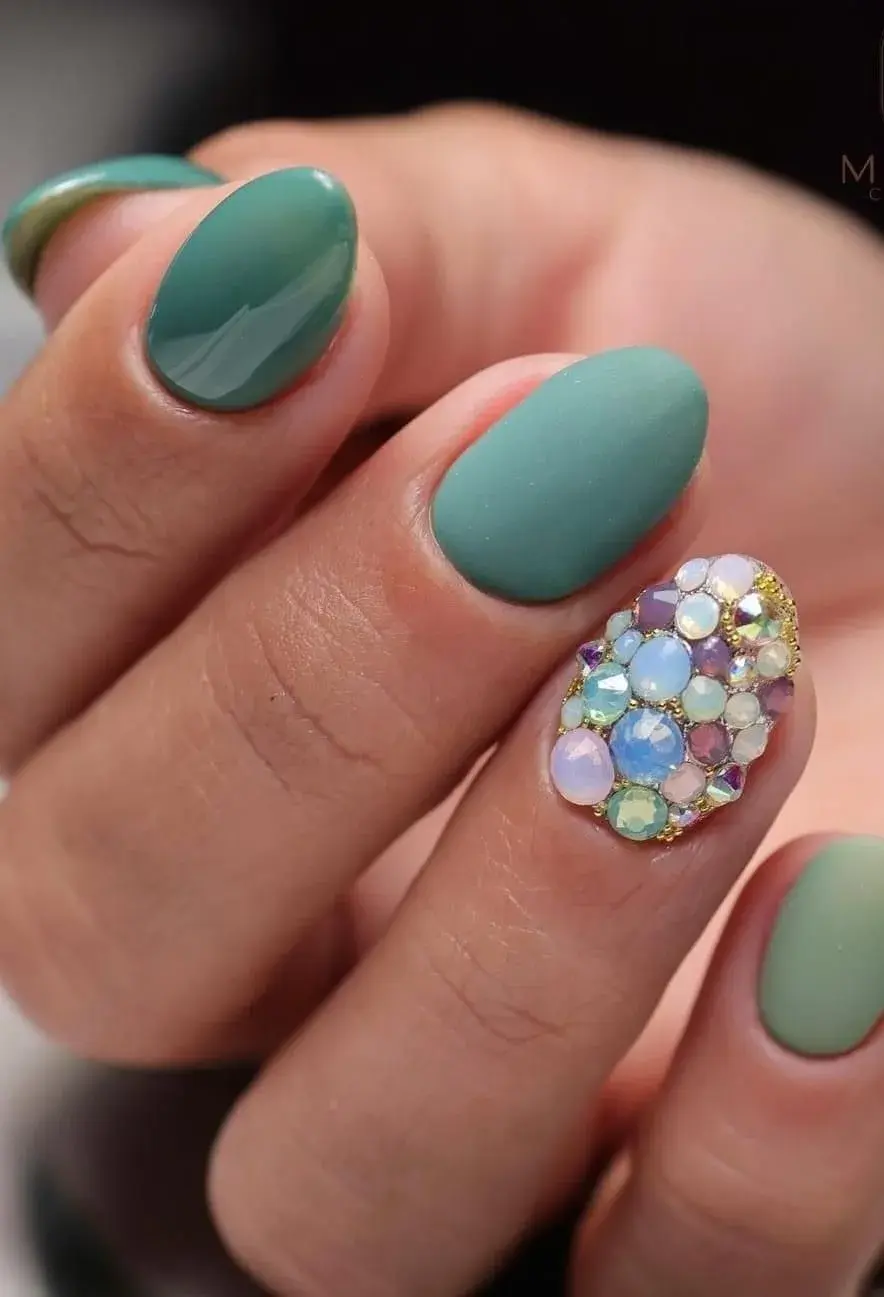 Diseños de uñas cortas para fin de año: Tonos joya con toques brillantes.