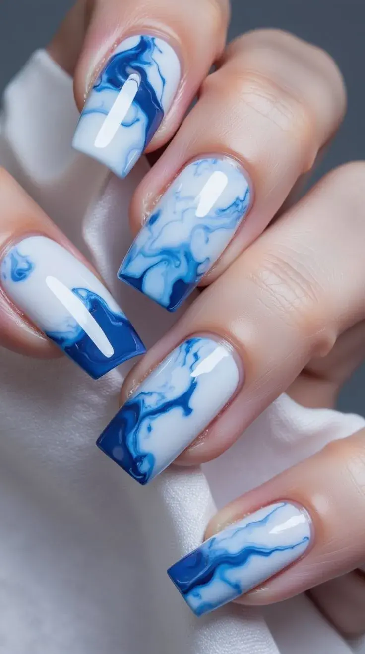 Combinar azul claro con blanco y líneas finas o florales produce una manicura que parece obra de arte —ideal para quienes buscan individualidad en su nail art.