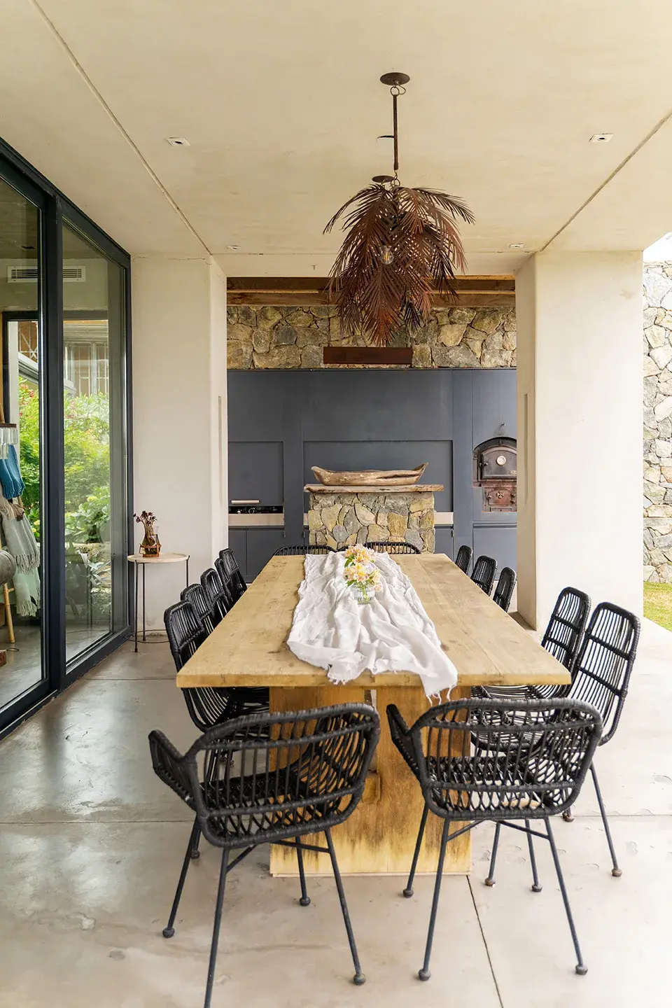 El revestimiento de la chimenea suma aún más calidez a este living con vista al exterior y, más allá, a la laguna.