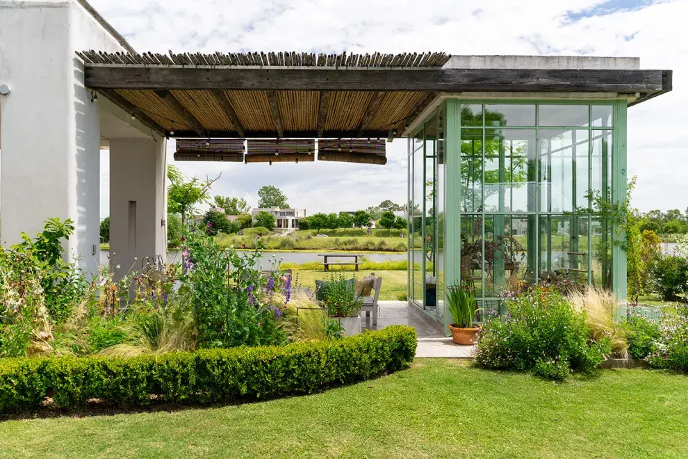 La perlita de la casa: el jardín de invierno con vidrio repartido y aberturas en verde agua.