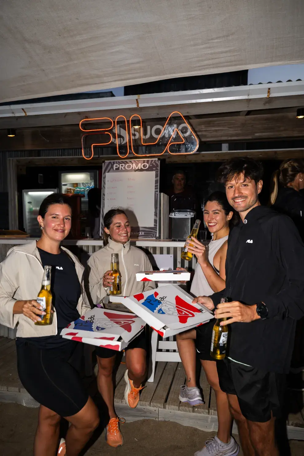 Chicas y chicos compartiendo una pizza y una cerveza