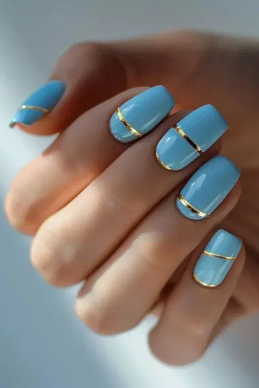 Incorporar detalles en dorado o plateado sobre un fondo azul transforma tu manicura en algo más sofisticado y festivo.