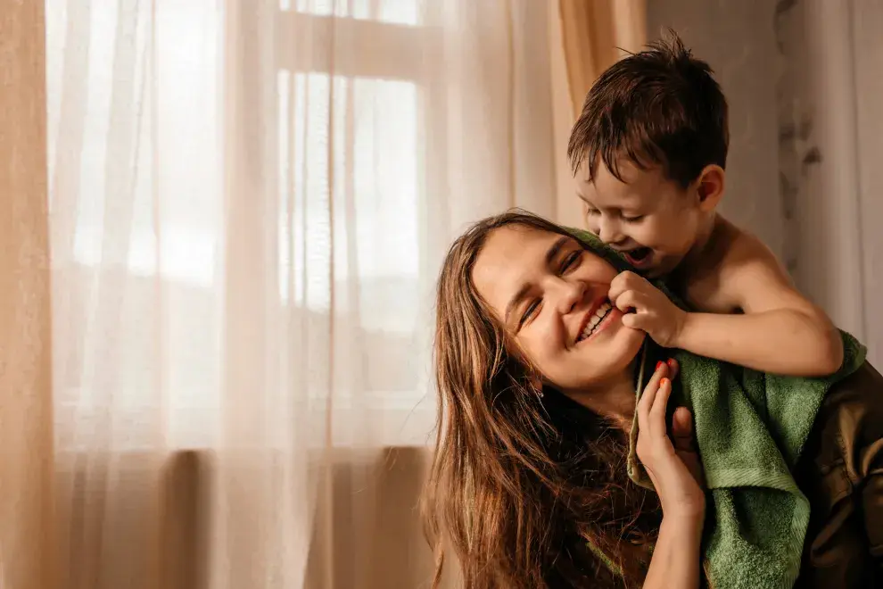 Foto de mujer jugando con su hijo.