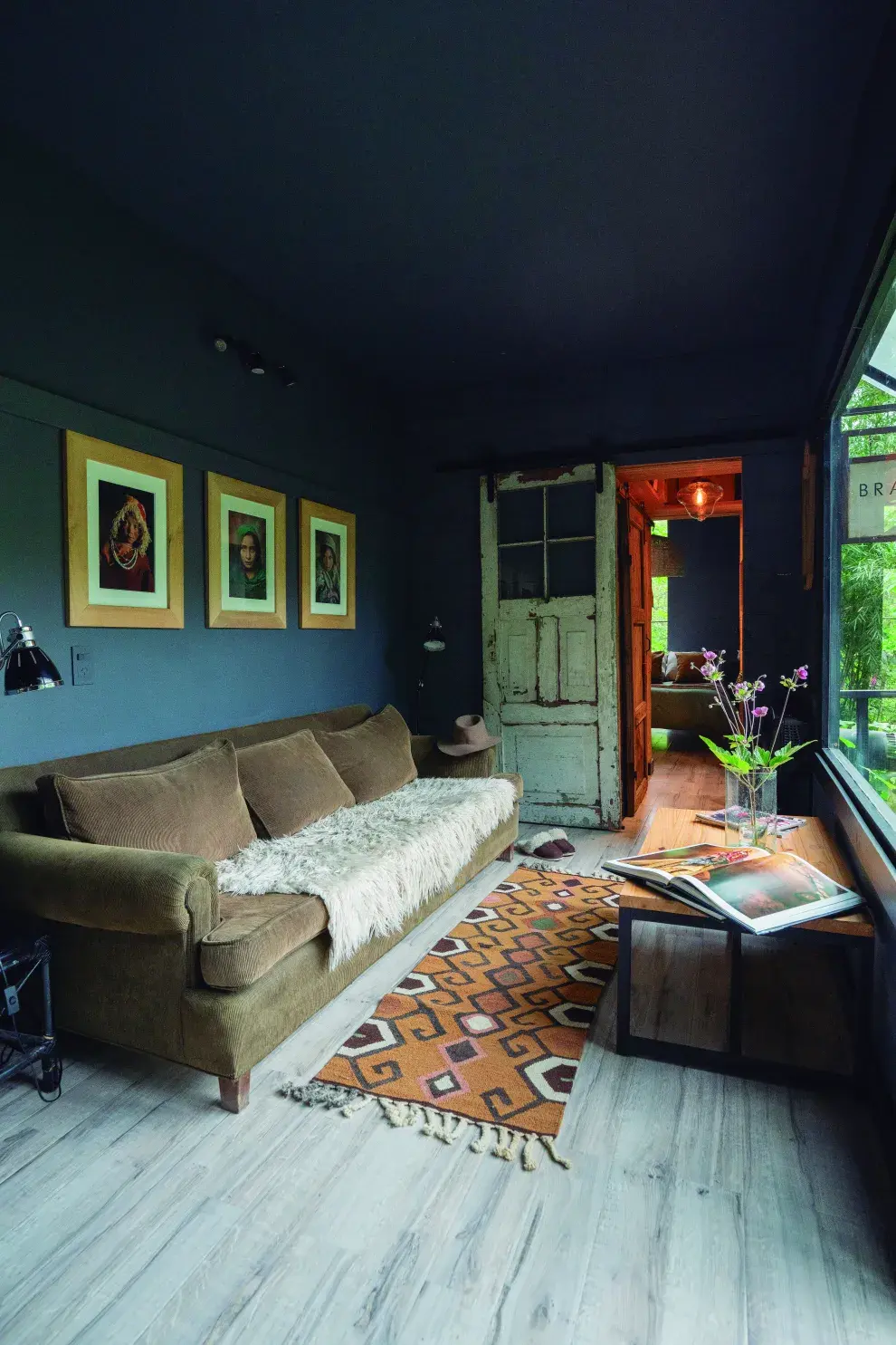 El living mira al ventanal, que explota de verde. Lo armó con un sillón amplio, una alfombra artesanal (@galponiadeco) y una mesa ratona con libros inspiradores.