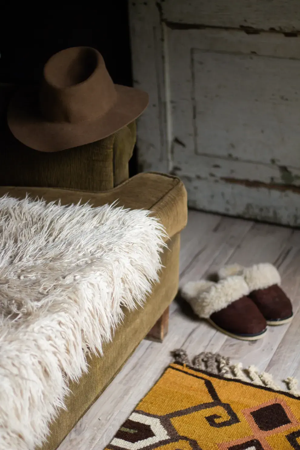 Cama vestida con acolchado verde, manta suave y almohadones blancos y tostados. Para el desayuno, bandeja de mimbre con tacita de cerámica (todo, @gakponiadeco).